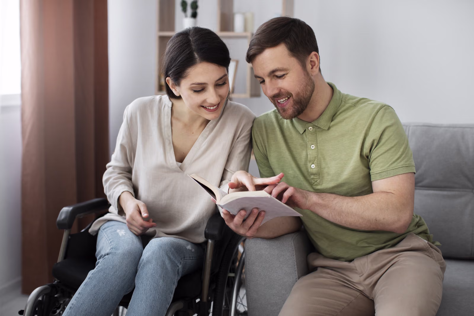 Two adults sitting together on a sofa sharing a book